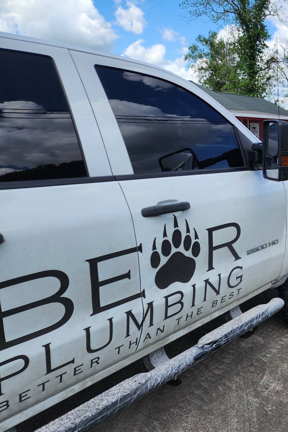 White BEAR Plumbing work truck with bear paw logo on the door